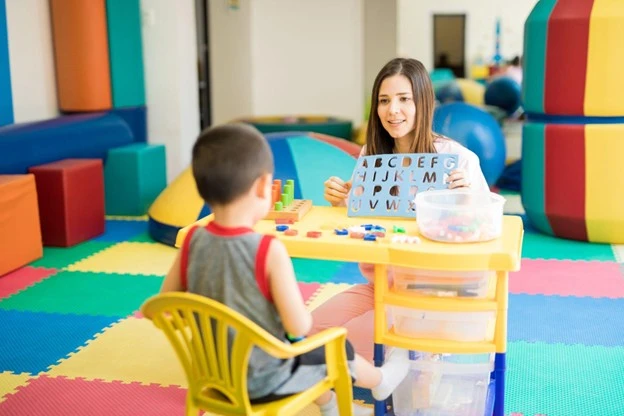 Teacher teaching young student the alphabet