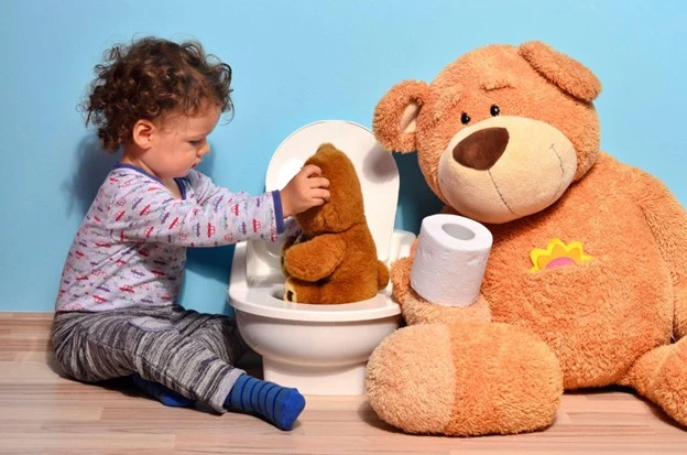 Child playing with toy toilet